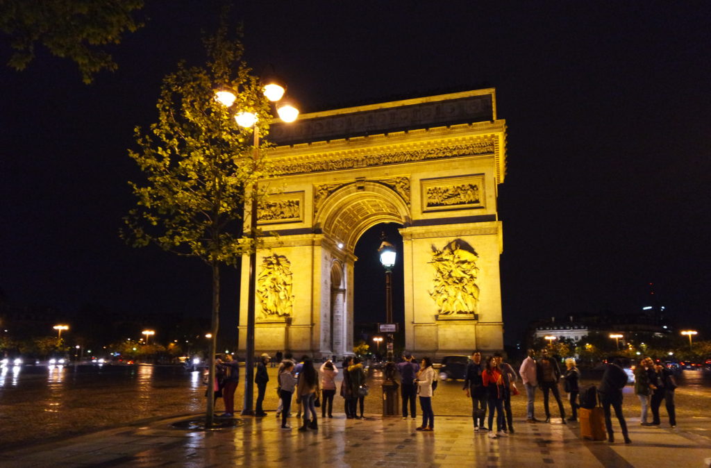 Arco do Triunfo iluminado, à noite, em Paris