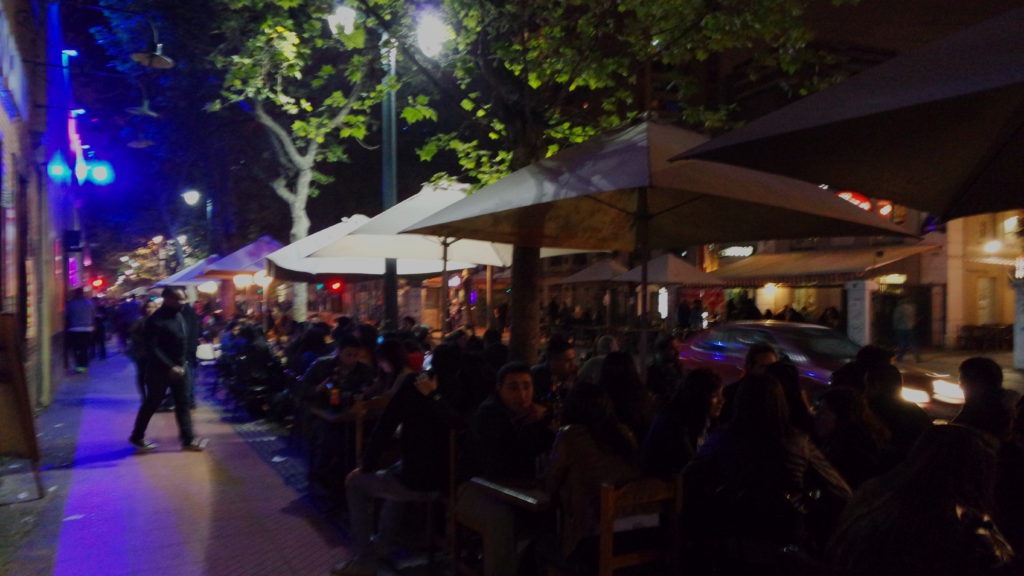 Cadeiras na calçada do bairro Bellavista de Santiago, à noite