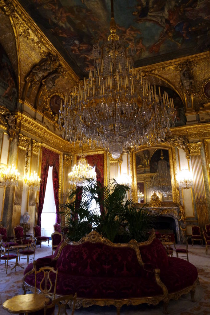 Ornamentação suntuosa com cristais e paredes em tom de outro, nos apartamentos de Napoleão, no Museu do Louvre