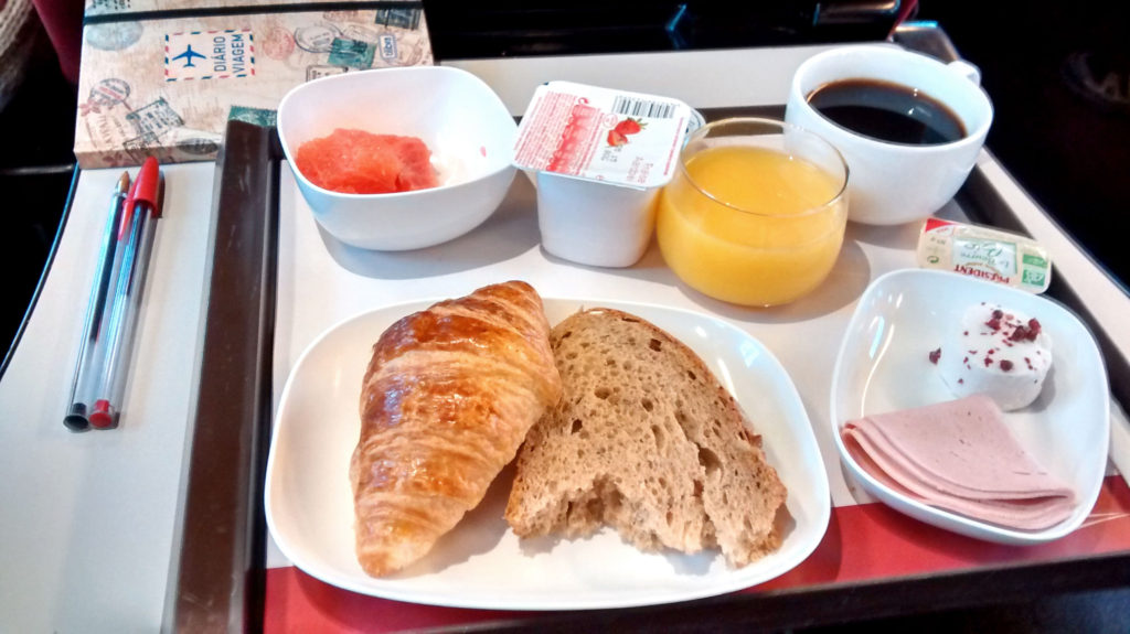 Café da manhã com croissant, pão, suco, iorgute